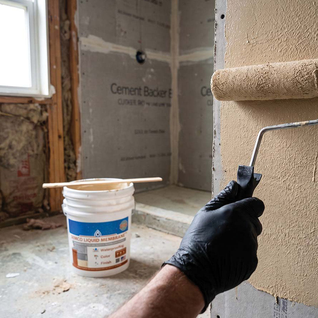 Embedding fabric waterproofing reinforcement into a shower niche corner before tiling